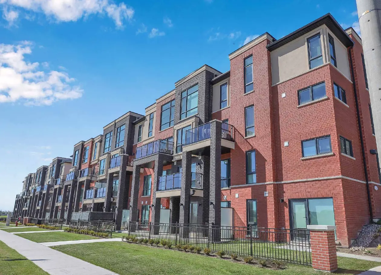 Photograph of the built Urban Towndominiums with brick and stucco facades and glass balconies